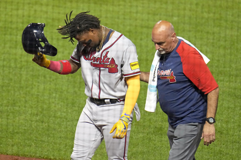 Atlanta Braves' Ronald Acuña Jr., left, leaves the field with a team trainer after being hit by a pitch from Pittsburgh Pirates reliever Colin Holderman during the sixth inning of a baseball game in Pittsburgh, Tuesday, Aug. 8, 2023. (AP Photo/Gene J. Puskar)
