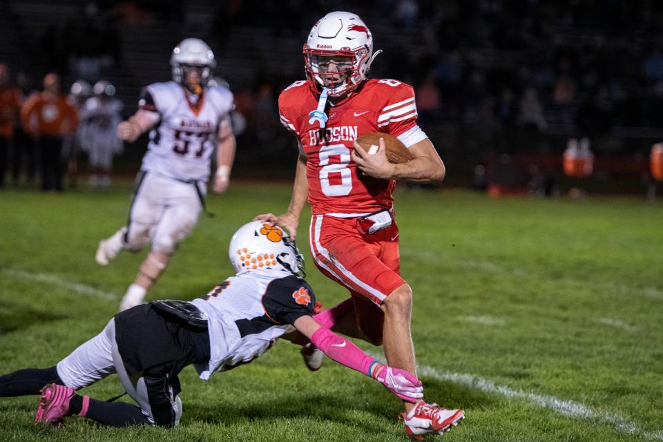 Hudson senior quarterback Jake Attaway runs around a Maynard defender during the game at Morgan Bowl, Oct. 5, 2024. The Hawks defeated the Tigers, 63-28.