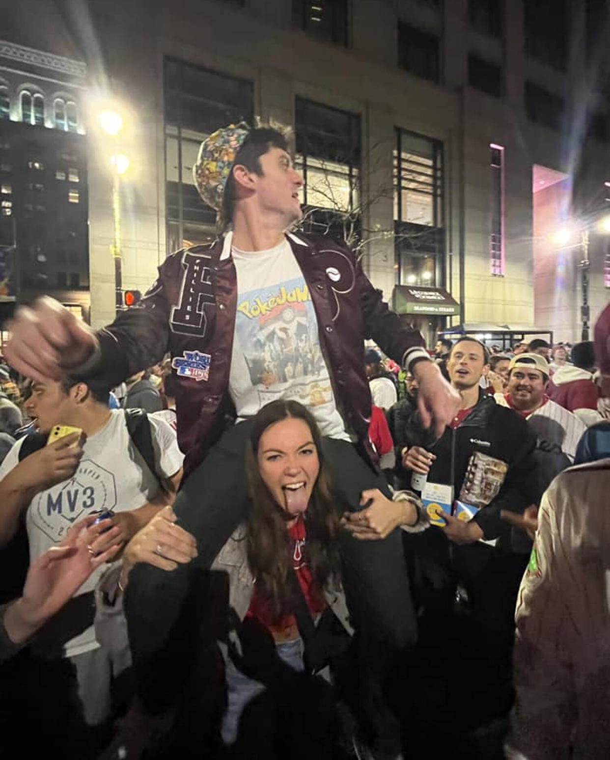 Seconds after they met, Erin Sweeney hoisted Jim Lindrooth atop her shoulders so he could find his friends in a crowd of Phillies fans outside City Hall in Philadelphia