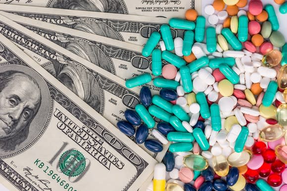 Colorful pills on a pile of cash money.