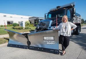 Sarah Lauber pictured at Douglas Dynamics Headquarters with Western MVP 3TM V-plow and truck upfit with Henderson Products stainless steel dump body