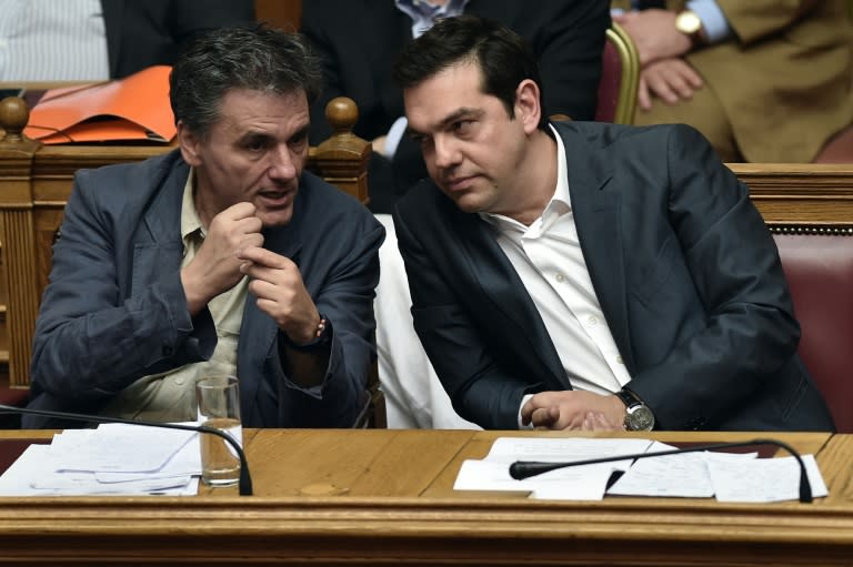 Greek Prime Minister Alexis Tsipras (R) and Finance Minister Euclid Tsakalotos attend a parliamentary session in Athens on July 15, 2015