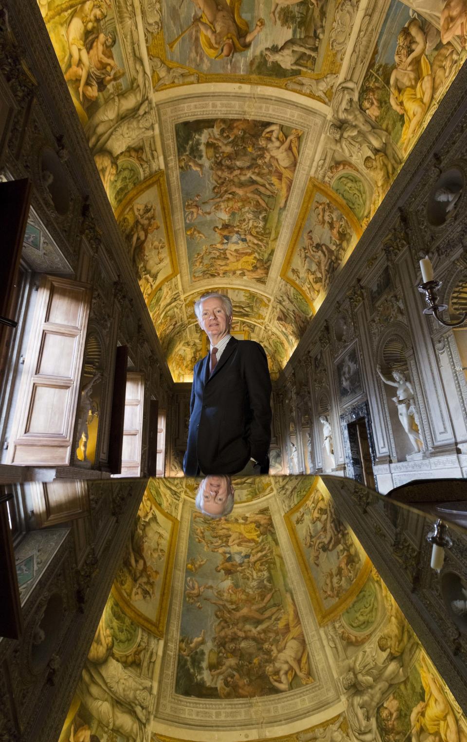 President of World Monuments Fund Europe, Bertrand du Vignaud poses in front of a mirror strategically positioned to allow visitors to admire the splendour of the frescoed ceilings of the Carracci Gallery in the Farnese Palace that hosts the French Embassy in Rome, Wednesday, Feb. 26, 2014. The World Monuments Fund Europe will allocate some 800 million Euros for the restoration of the about 140 square meters of 16th century frescoes by Annibale and Agostino Carracci that will begin mid March and expected to be completed in 2015. (AP Photo/Domenico Stinellis)