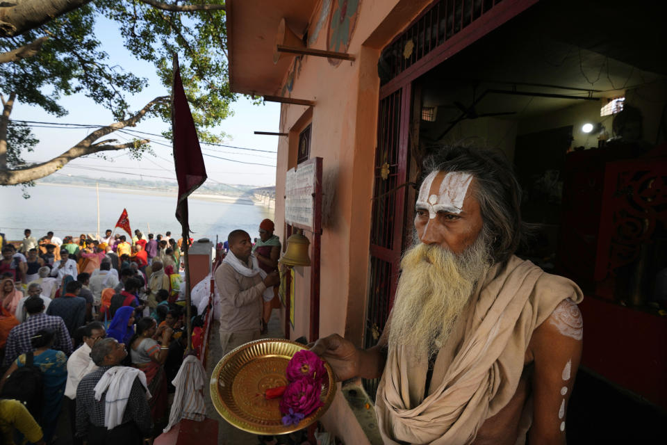 A Hindu priest prays on the bank of the river Saryu on the occasion of Ramnavi festival, celebrated as the birthday of Hindu god Ram, in Ayodhya, India, March 30, 2023. India is on the cusp to eclipse China as the world's most populated country, but its religious fault lines have become starker, a testament to the perils of rising Hindu nationalism in a constitutionally secular country. (AP Photo/Manish Swarup)