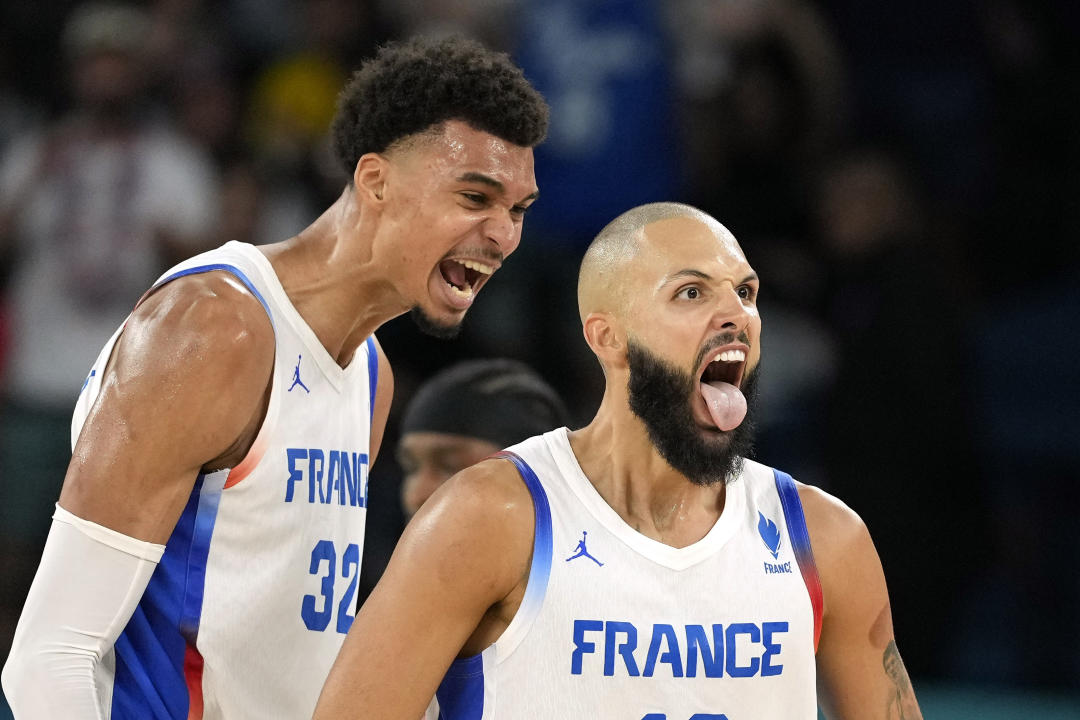 Pemain Prancis Evan Fournier (tengah) merayakan golnya bersama pemain Prancis Victor Wembanyama (kanan) setelah mencetak gol dalam pertandingan bola basket putra melawan Kanada di Olimpiade Musim Panas 2024, Selasa, 6 Agustus 2024, di Paris, Prancis. (Foto AP/Michael Conroy)