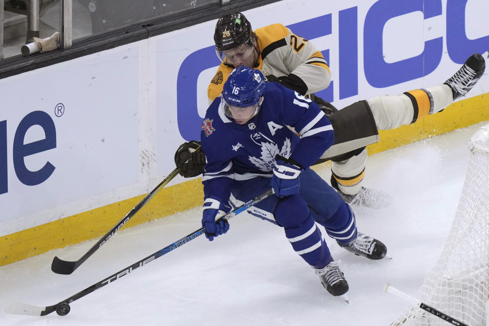 Toronto Maple Leafs right wing Mitchell Marner, front, and Boston Bruins defenseman Brandon Carlo vie for control of the puck during the first period of an NHL hockey game Thursday, Nov. 2, 2023, in Boston. (AP Photo/Steven Senne)