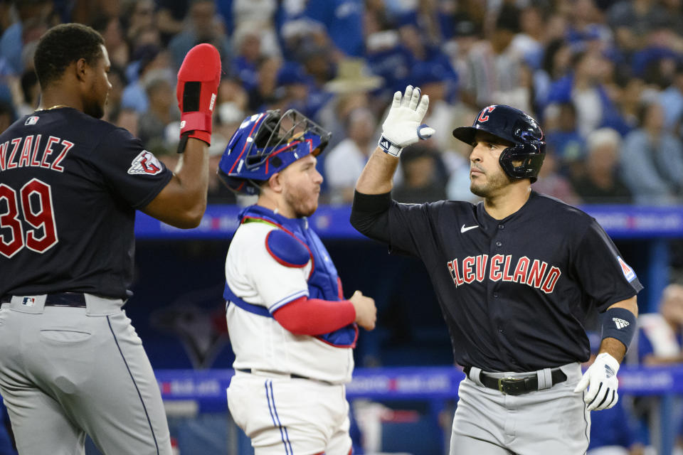 Cleveland Guardians' Ramon Laureano, right, celebrates his two-run home run with Oscar Gonzalez (39), next to Toronto Blue Jays catcher Alejandro Kirk during the fourth inning of a baseball game Friday, Aug. 25, 2023, in Toronto. (Christopher Katsarov/The Canadian Press via AP)