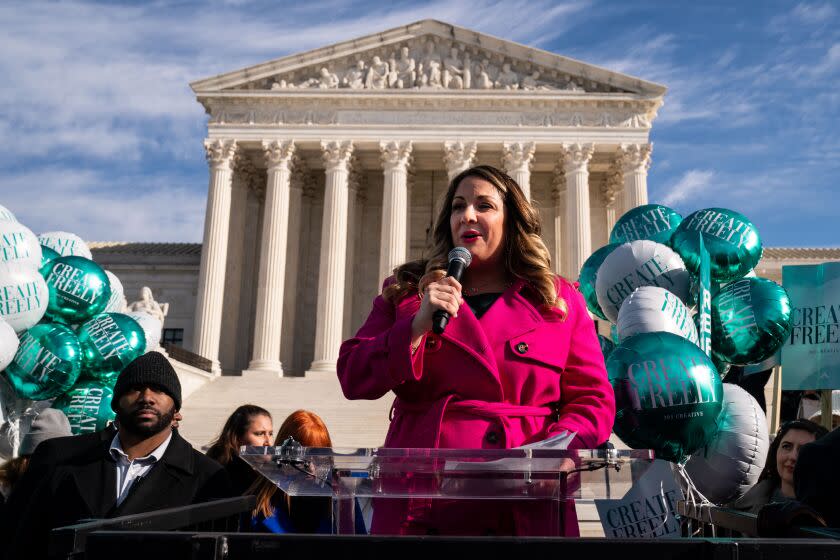 WASHINGTON, DC - DECEMBER 05: Lorie Smith, a Christian graphic artist and website designer in Colorado, center in pink, speaks to supporters outside the Supreme Court on Monday, Dec. 5, 2022 in Washington, DC. The High Court heard oral arguments in a case involving a suit filed by Lorie Smith, owner of 303 Creative, a website design company in Colorado who refused to create websites for same-sex weddings despite a state anti-discrimination law. (Kent Nishimura / Los Angeles Times)