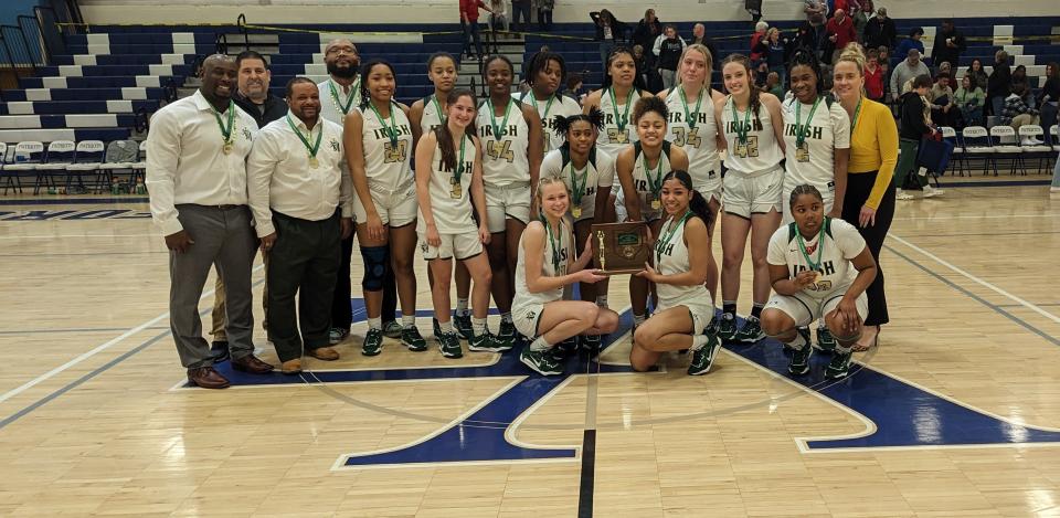 The St Vincent-St. Mary girls basketball team poses with its district championship trophy after beating Norton on Saturday, Feb. 25, 2023.