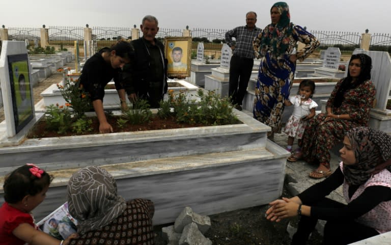 Syrian Kurds visit graves of loved ones at a cemetery in the northern town of Kobane on May 28, 2018