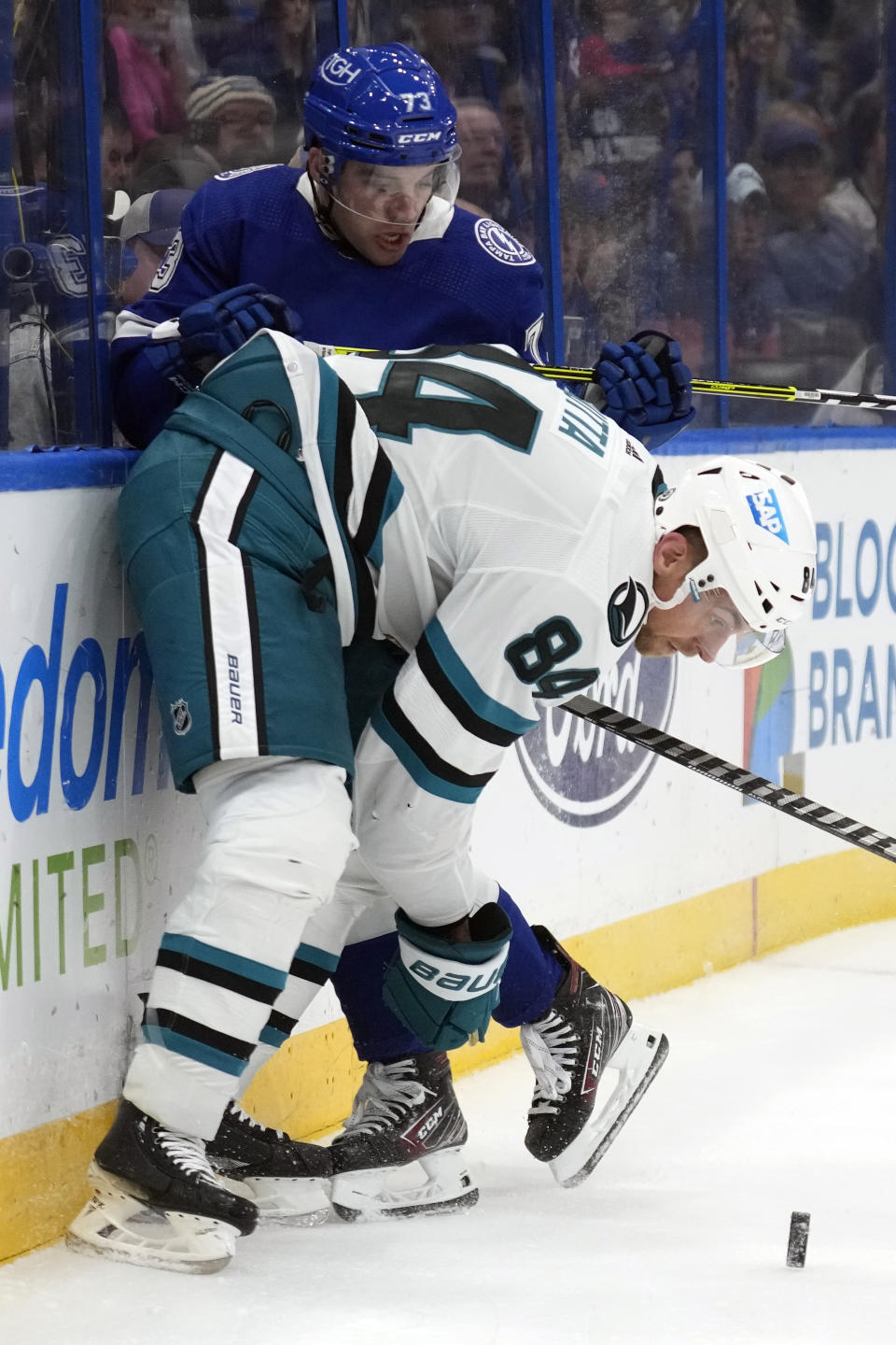 San Jose Sharks defenseman Jan Rutta (84) checks Tampa Bay Lightning left wing Conor Sheary (73) in the boards during the second period of an NHL hockey game Thursday, Oct. 26, 2023, in Tampa, Fla. (AP Photo/Chris O'Meara)