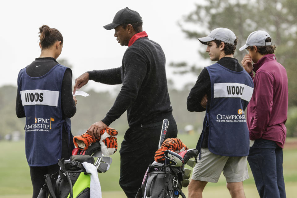 Team Woods, Sam, left; Tiger, center left; Luke Wise, center right; and Charlie, right; stand on third green during the final round of the PNC Championship golf tournament, Sunday, Dec. 17, 2023, in Orlando, Fla. (AP Photo/Kevin Kolczynski)