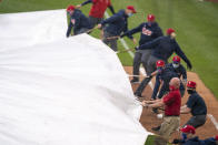 Philadelphia Phillies ground crew covers the field as a rain delay is called during the third inning of a baseball game against the San Francisco Giants, Wednesday, April 21, 2021, in Philadelphia. (AP Photo/Chris Szagola)