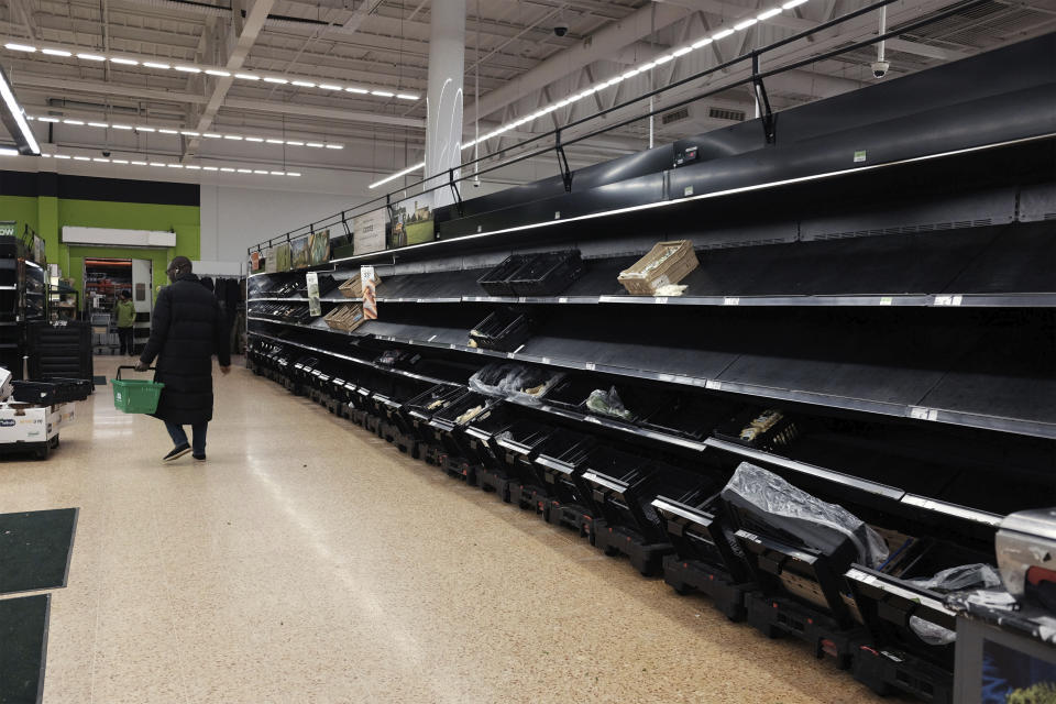 Shelves are empty in the fruit and vegetable section of an Asda store in London on Saturday, March 14, 2020. (Yui Mok/PA via AP)