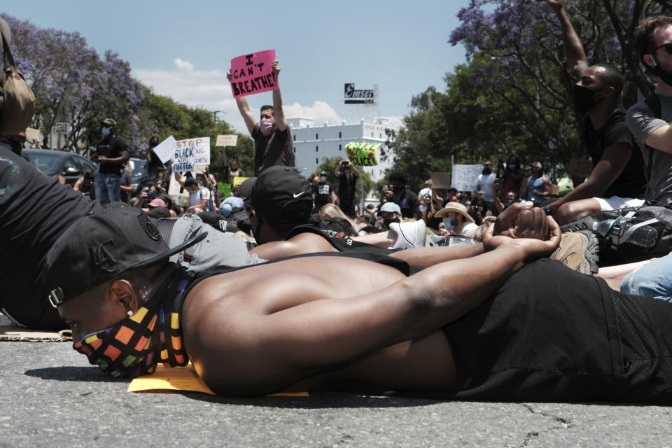 Devion Coleman joins LGBTQ community members and Black Lives Matter protesters as they lay on the street with their hands on their backs in West Hollywood, Calif. on Wednesday, June 3, 2020, over the death of George Floyd, a black man who died in police custody in Minneapolis on Memorial Day. (AP Photo/Richard Vogel)