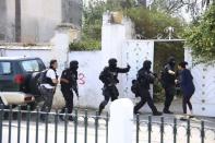 Tunisian anti-terrorism brigade personnel enter a house to take position after a shooting at the Bouchoucha military base in Tunis, Tunisia May 25, 2015. REUTERS/Zoubeir Souissi