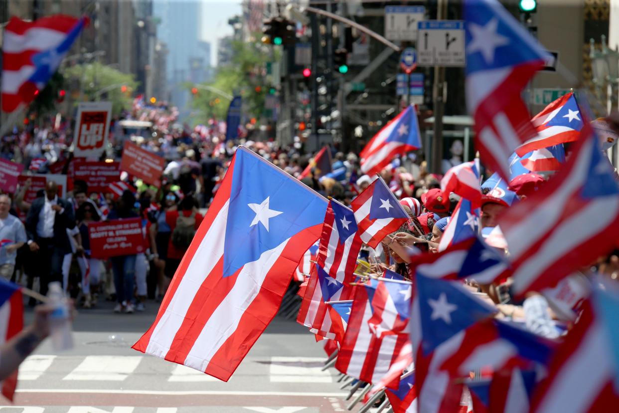 Parade attendees wave Puerto Rican flags on Fifth Avenue in Manhattan during the annual Puerto Rico Day Parade in 2019.