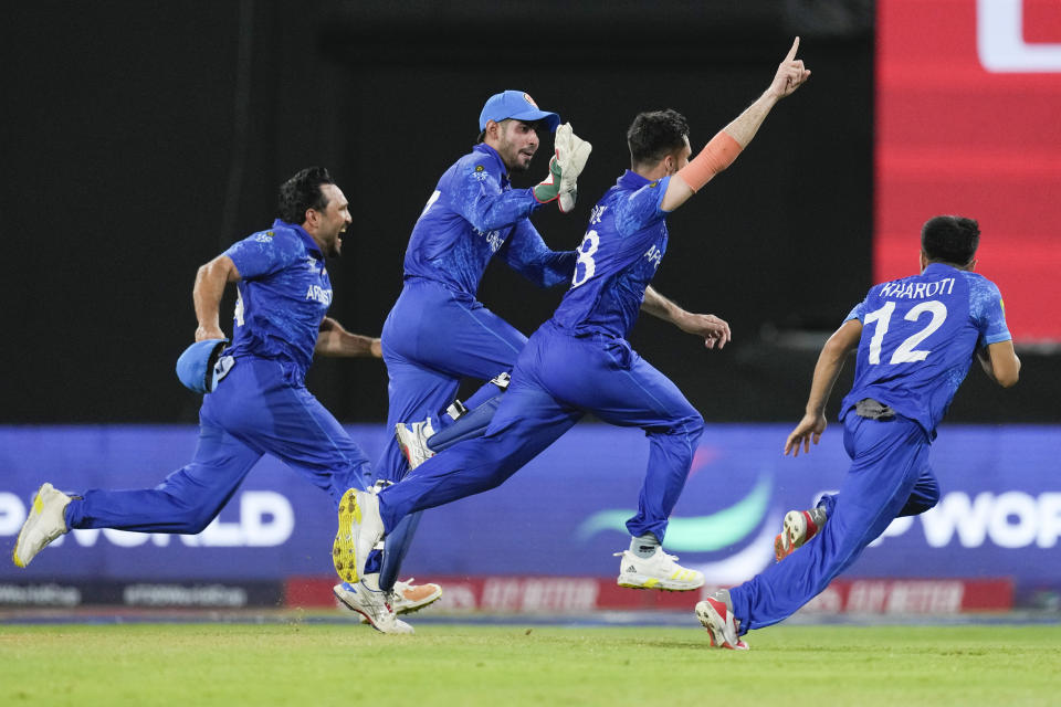 Afghanistan's Ibrahim Zadran, centre, reacts with teammates after taking the wicket of Bangladesh's Mustafizur Rahman to win by eight runs in their men's T20 World Cup cricket match at Arnos Vale Ground, Kingstown, Saint Vincent and the Grenadines, Monday, June 24, 2024. (AP Photo/Ricardo Mazalan)