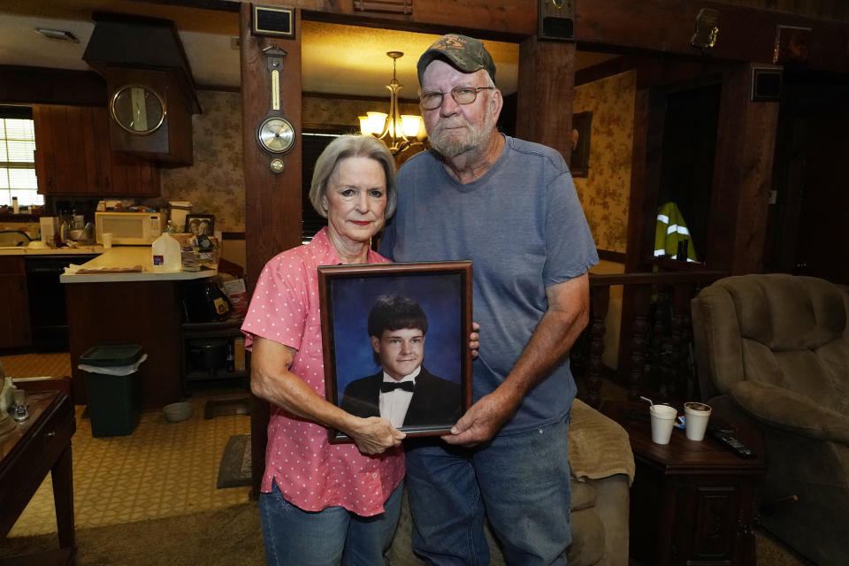 Andrea Breedlove, left, holds a high school portrait of her late son, Chase Brewer, with her husband and Brewer's step-father, Johnny Breedlove, in their home in the Carpenter community near Crystal Springs, Miss., Tuesday, Aug. 9, 2022. Brewer was shot and killed by U.S. Drug Enforcement Administration Agent Harold Duane Poole with his semiautomatic service rifle on April 27, 2021. Records obtained by The Associated Press raise new questions about how Poole avoided trial and whether DEA brass overreached to protect one of their own amid a flurry of misconduct cases. (AP Photo/Rogelio V. Solis)