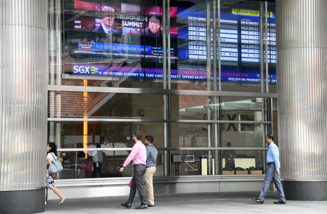 People walk outside the SGX stock exchange building in Singapore on June 13, 2018. (Photo by ROSLAN RAHMAN / AFP)        (Photo credit should read ROSLAN RAHMAN/AFP via Getty Images)