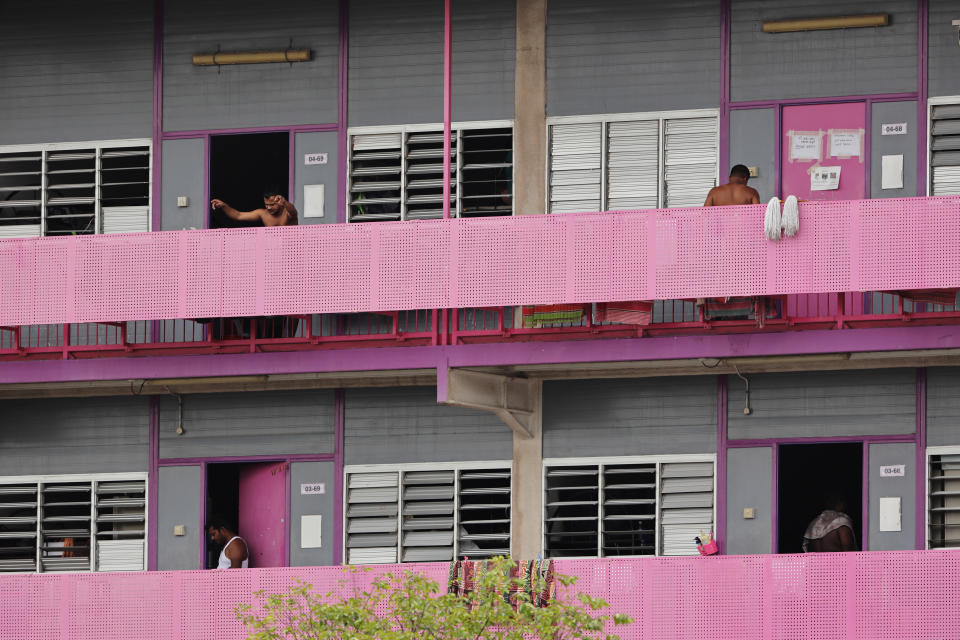 SINGAPORE - APRIL 29:  Foreign workers are seen at the door of their dormitory room on April 29, 2020 in Singapore. Singapore is now battling to control a huge outbreak in the coronavirus (COVID-19) local transmission cases among the migrant workers.  (Photo by Suhaimi Abdullah/Getty Images)