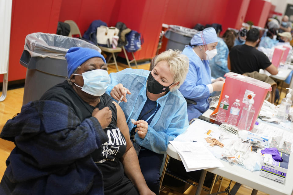 Mary Jenkins, left, received the COVID-19 vaccine in Paterson, N.J., Thursday, Jan. 21, 2021. The first people arrived around 2:30 a.m. for the chance to be vaccinated at one of the few sites that does not require an appointment. (AP/Seth Wenig)