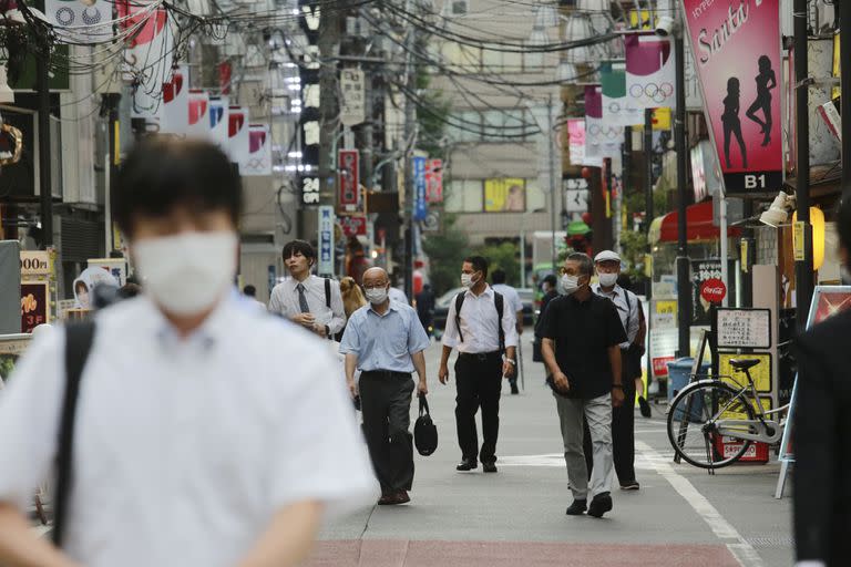 Unas personas caminan por una calle en Tokio, Japón, el 31 de agosto de 2021. (AP Foto/Koji Sasahara)