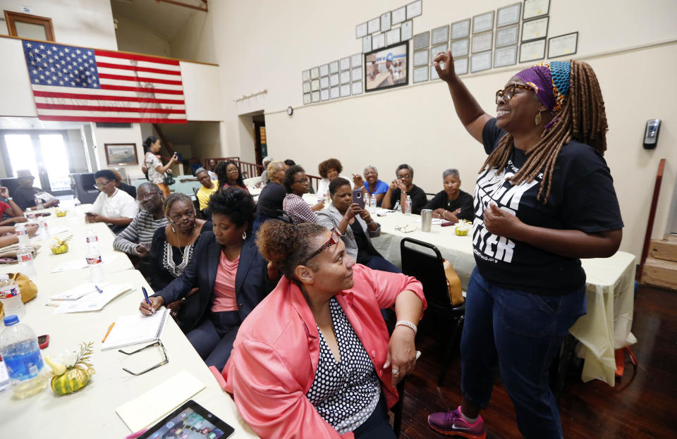 In this Aug. 24, 2018 photograph, LaTosha Brown, right, co-founder of Black Voters Matter, breaks out with an organizing song at a meeting of several Mississippi grassroots organizations at MACE, Mississippi Action for Community Education, headquarters in Greenville, Miss. Brown said the time is now for black women to lead again. She pointed to incidents like the attempt to close a majority of polling places in Randolph County, Ga., in August, as proof of the need for the kind of continued vigilance black women have long provided. (AP Photo/Rogelio V. Solis)