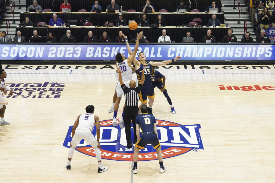 Furman forward Jalen Slawson and Chattanooga center Jake Stephens tip off for the start of the NCAA men"s college basketball championship game for the Southern Conference tournament, Monday, March 6, 2023, in Asheville, N.C. (AP Photo/Kathy Kmonicek)