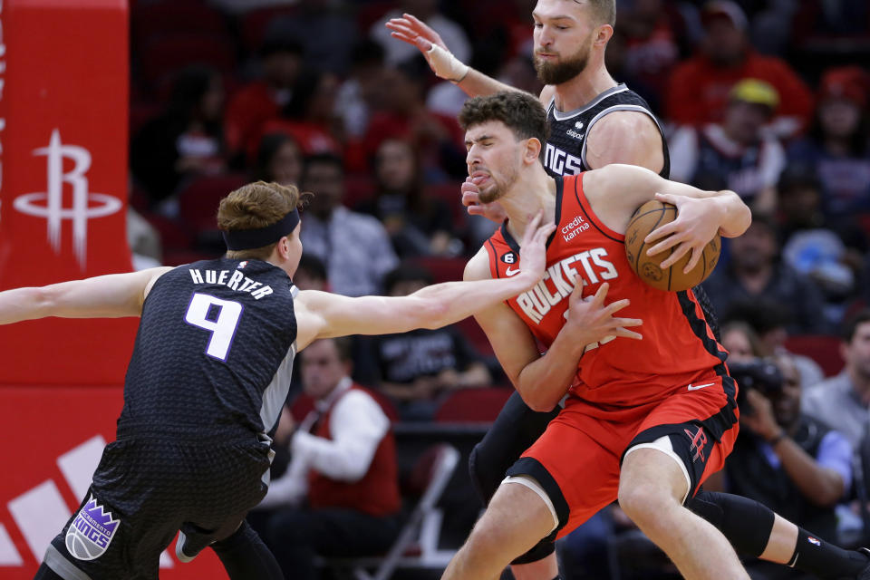 Houston Rockets center Alperen Sengun, right front, is fouled by Sacramento Kings guard Kevin Huerter (9) in front of forward Domantas Sabonis, right back, during the first half of an NBA basketball game Wednesday, Feb. 8, 2023, in Houston. (AP Photo/Michael Wyke)
