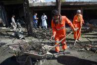 Afghan municipality workers clear the site after a car bomb attack in western Kabul