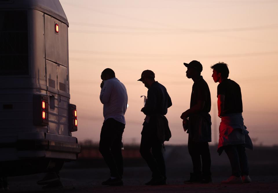 Immigrants seeking asylum, wait to board a bus to a U.S. Border Patrol processing center, after crossing into Arizona from Mexico, on May 11, 2023 in Yuma, Arizona.