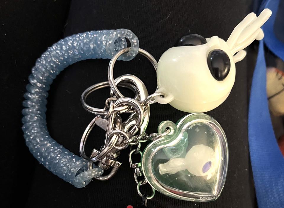 a baby alien in a heart shaped bubble and a bigger alien on the keychain