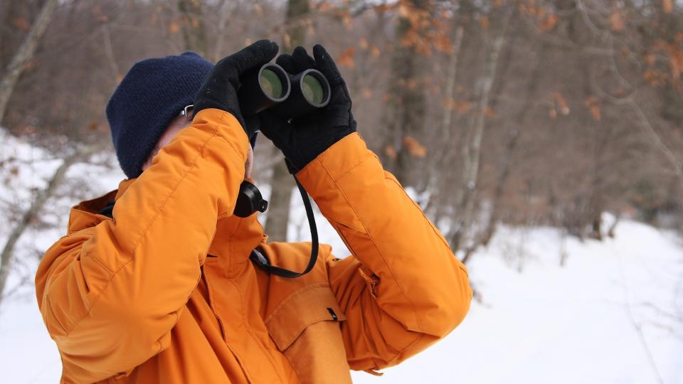 man using binoculars during winter