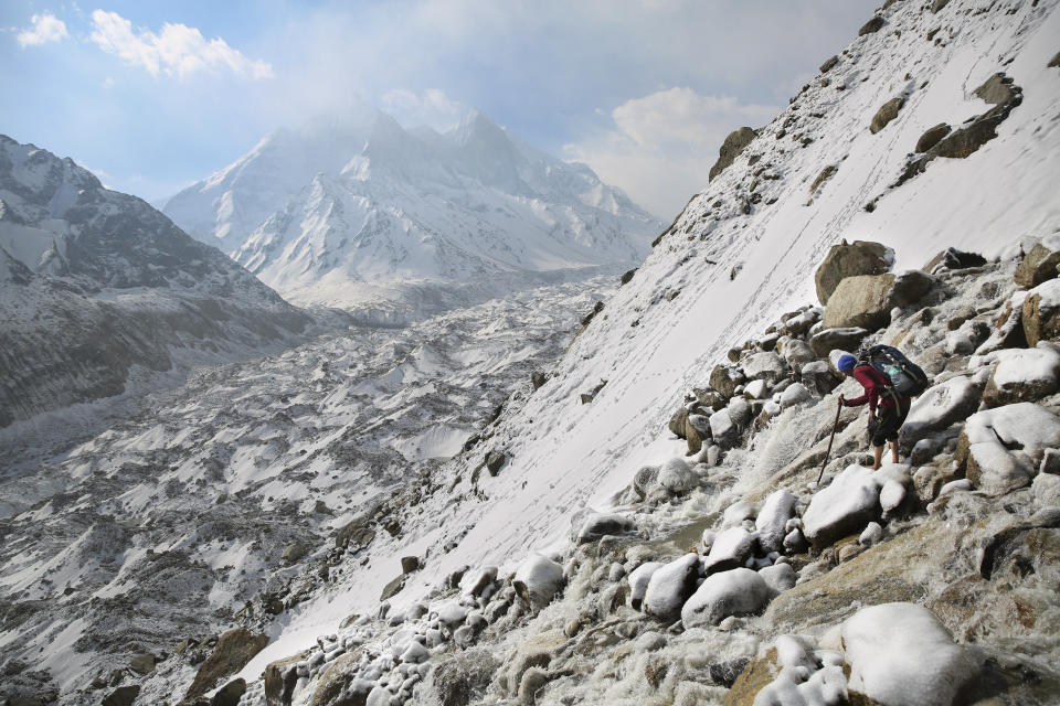 Tourist guide Suresh Panwar navigates icy rocks as he descends a steep mountain ridge in the backdrop of the Bhagirathi peaks and the huge expanse of the Gangotri glacier at an altitude of 4500 meters in the northern Indian state of Uttarakhand, Saturday, May 11, 2019. Bhagirathi peaks feed the Gangotri Glacier which is one of the primary sources of water for the Ganges. This glacier has provided enough water to the arid plains it flows through, even during the driest months. Available data shows that Gangotri Glacier is receding at a frightening pace. (AP Photo/Altaf Qadri)