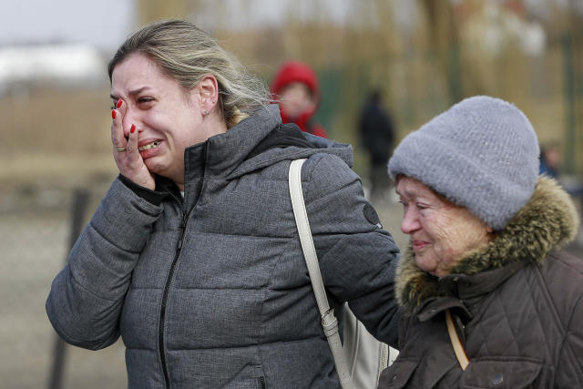 Two women cry at a border crossing in Poland.