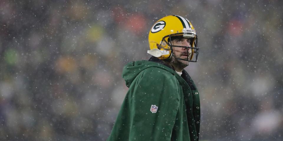 Aaron Rodgers looks up as snow falls during the Packers playoff game against the 49ers in 2022.