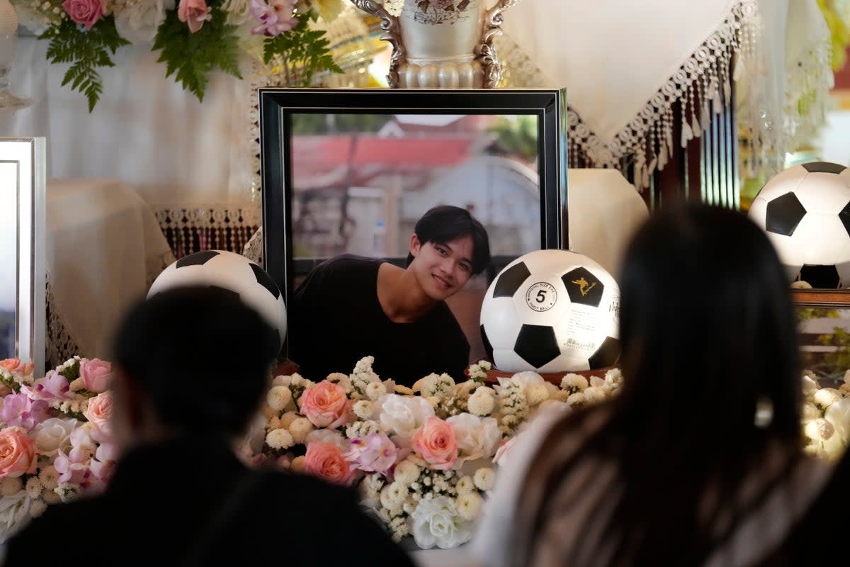 Family members sit in front of portrait of Duangphet Phromthep during his funeral at Wat Phra That Doi Wao temple in Chiang Rai province Thailand, Sunday, March 5 (AP)