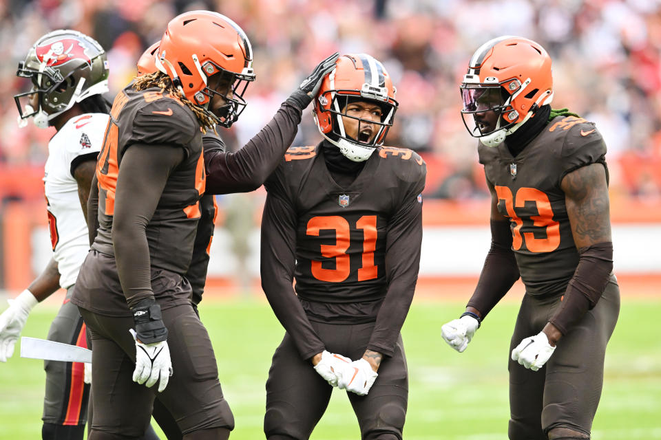 Nov 27, 2022; Cleveland, Ohio, USA; Cleveland Browns defensive end Alex Wright (94) and cornerback Thomas Graham Jr. (31) and safety Ronnie Harrison Jr. (33) celebrate after a stop during the second half against the Tampa Bay Buccaneers at FirstEnergy Stadium. Mandatory Credit: Ken Blaze-USA TODAY Sports