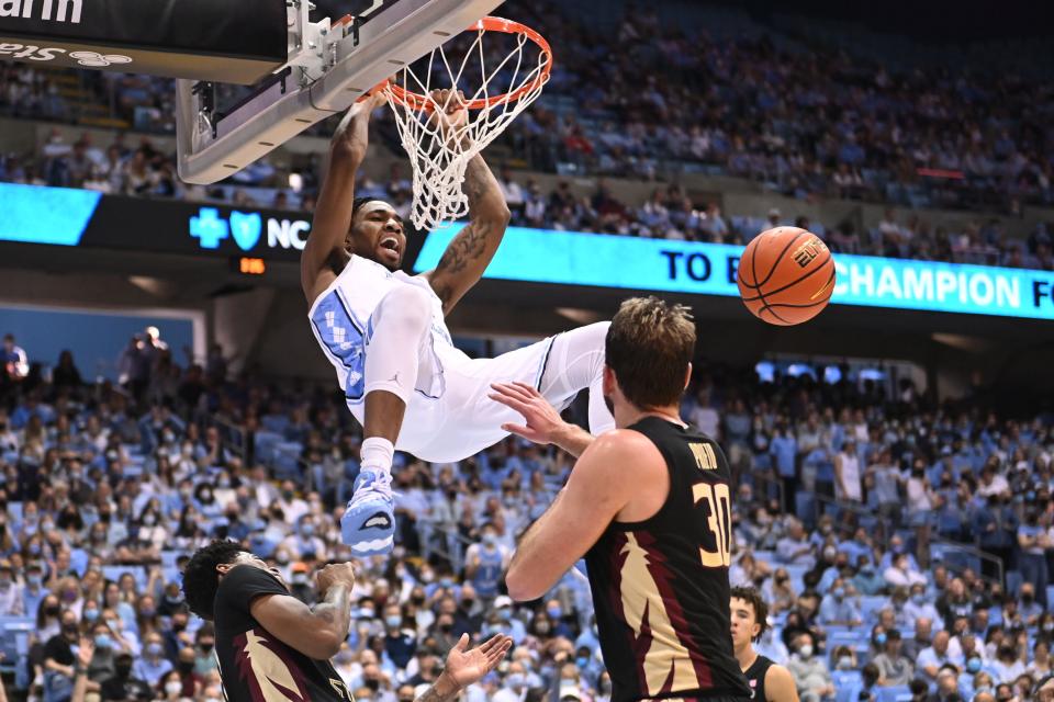 Feb 12, 2022; Chapel Hill, North Carolina, USA; North Carolina Tar Heels guard Dontrez Styles (3) scores as Florida State Seminoles guard Cam'Ron Fletcher (21) and forward Harrison Prieto (30) defend in the second half at Dean E. Smith Center.