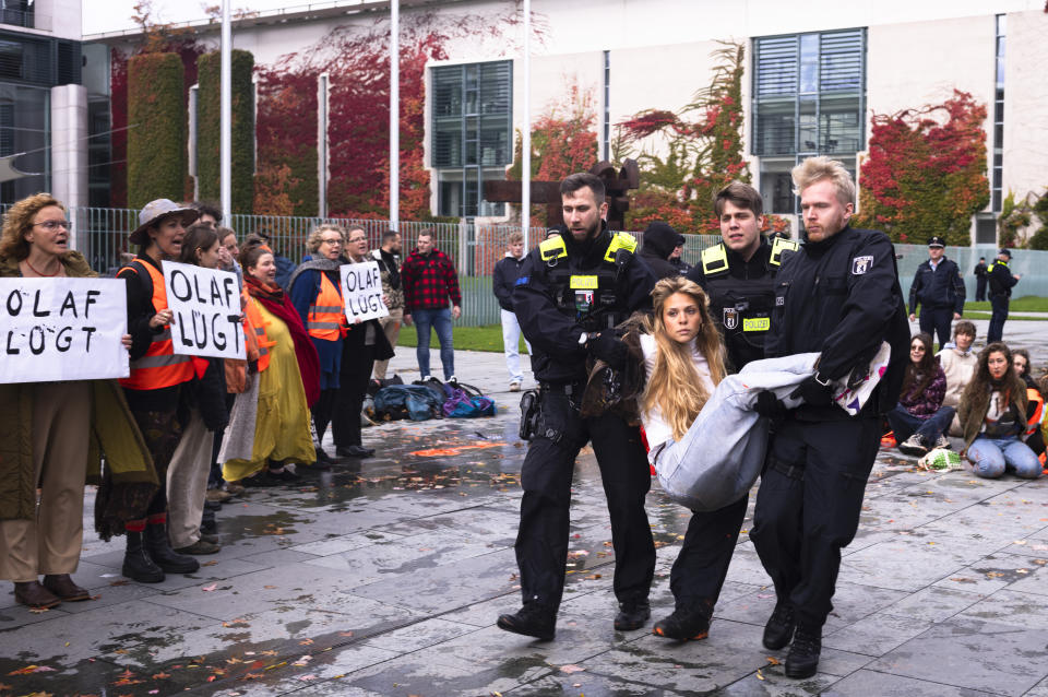 Police officers carry away an activist of the 'Letzte Generation' (Last Generation) during a climate protest against the government's climate policy in front of the chancellery in Berlin, Germany, Tuesday, Oct. 31, 2023. A group of climate activists who have infuriated many in Germany by gluing themselves to streets to block traffic said Monday, Jan. 29, 2024 that it will abandon the tactic and move on to holding what it calls “disobedient assemblies.” The Last Generation group has frequently blocked roads in Berlin and other cities over the past two years, among other forms of protest(AP Photo/Markus Schreiber, file)