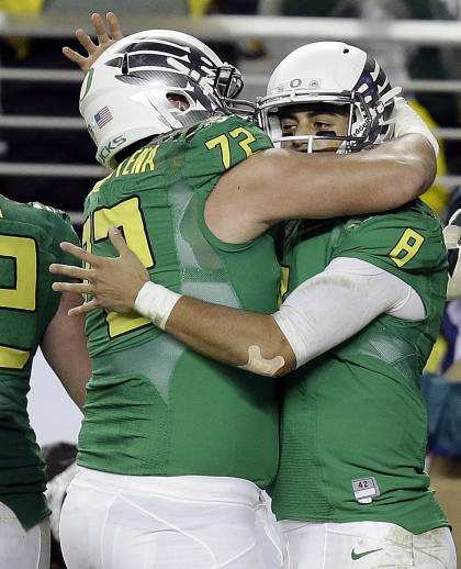 Oregon quarterback Marcus Mariota, right, is congratulated by Andre Yruretagoyena (72) after Mariota scored a touchdown against Arizona during the Pac-12 Conference championship. (AP Photo/Ben Margot)