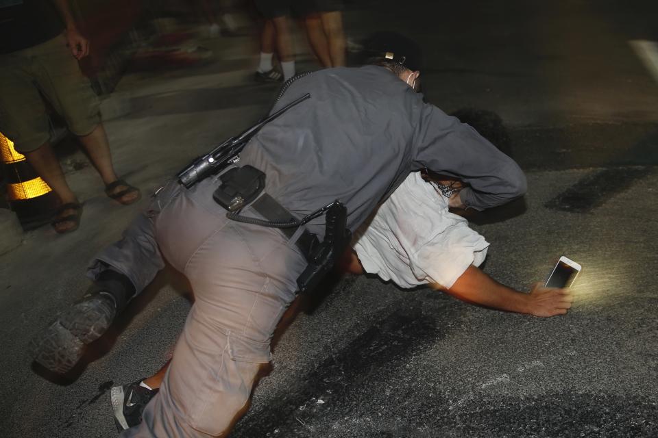 Israeli police officers arrest an Israeli protester during a demonstration against lockdown measures that they believe are aimed at curbing protests against prime minister Benjamin Netanyahu Tel Aviv, Israel, Saturday, Oct. 3, 2020. (AP Photo/Ariel Schalit)