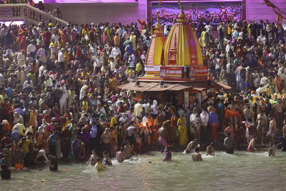 Devotees take holy dips in the Ganges River during Kumbh Mela, or pitcher festival, one of the most sacred pilgrimages in Hinduism, in Haridwar, northern state of Uttarakhand, India, Monday, April 12, 2021. Tens of thousands of Hindu devotees gathered by the Ganges River for special prayers Monday, many of them flouting social distancing practices as the coronavirus spreads in India with record speed. (AP Photo/Karma Sonam)