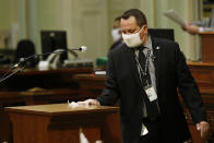 Assembly Sgt.-at-Arms Larry Williams disinfects the podium after its use by an Assembly member at the Capitol in Sacramento, Calif., Monday, June 8, 2020. The Assembly held its first full session, Monday, since going into a recess in March due to the coronavirus pandemic. (AP Photo/Rich Pedroncelli)