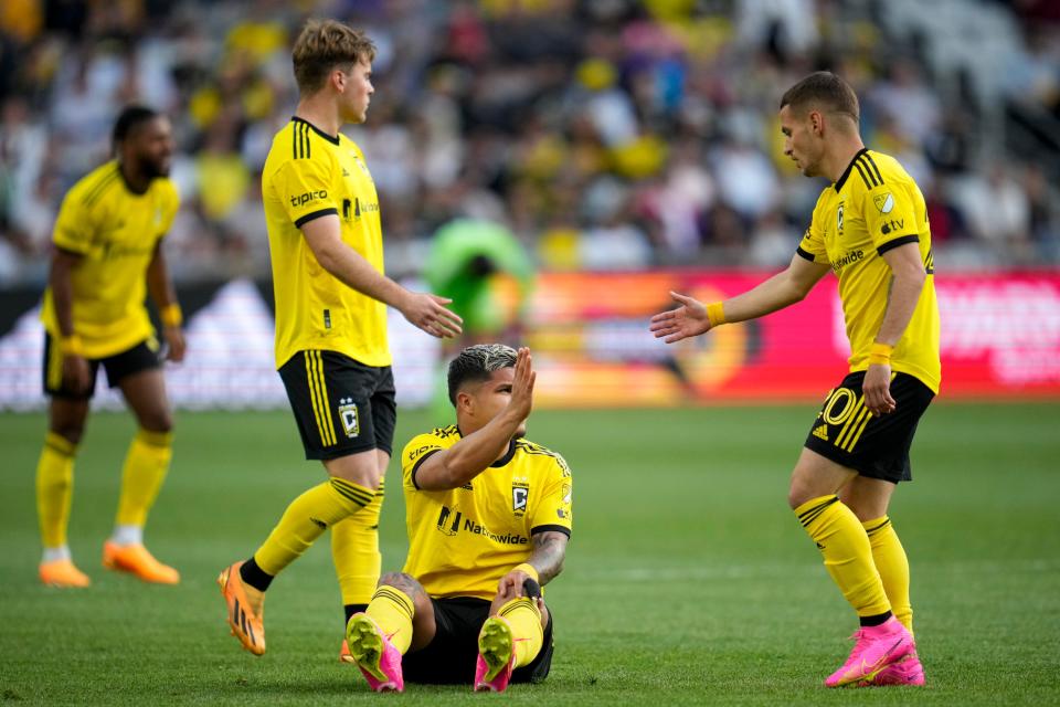 Crew midfielder Alexandru Matan offers a hand to forward Cucho Hernandez during Columbus' most recent home game, a 2-0 win over the Galaxy on May 17.