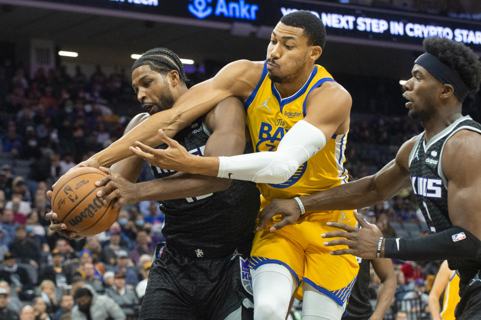 Sacramento Kings center Tristan Thompson, left, and Golden State Warriors forward Otto Porter Jr. wrestle to control the ball during the first quarter of an NBA basketball game in Sacramento, Calif., Sunday, Oct. 24, 2021. (AP Photo/Randall Benton)