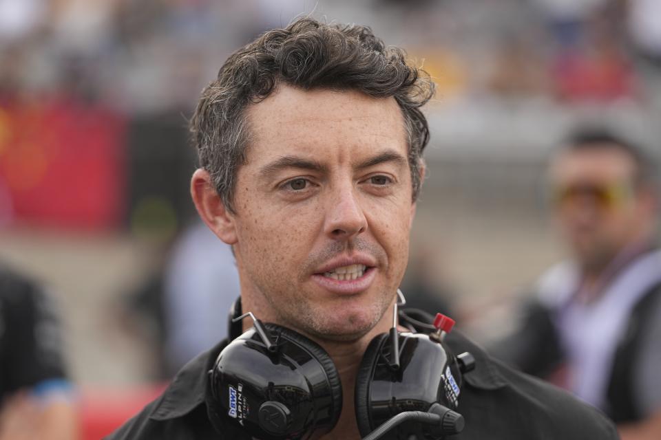 Rory McIlroy, right, of Northern Ireland, looks on while standing on the grid before the sprint ahead of the Formula One U.S. Grand Prix auto race at Circuit of the Americas,at Circuit of the Americas, Saturday, Oct. 21, 2023, in Austin, Texas. (AP Photo/Darron Cummings)