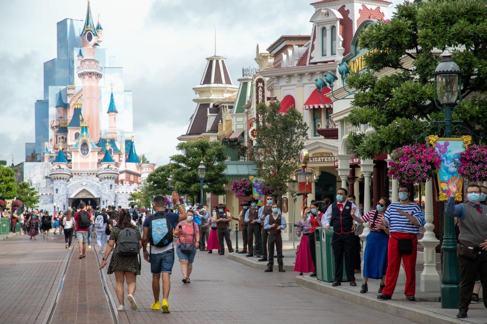 This image people walking towards the castle at Disneyland.