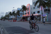 FILE - In this July 24, 2020, file photo, a sparse crowd is on Ocean Drive after an 8 p.m. curfew amid the coronavirus pandemic in Miami Beach, Fla. Families trying to get in a last-minute vacation before school starts better do some homework on COVID-19 restrictions before loading up the minivan. (AP Photo/Lynne Sladky, File)